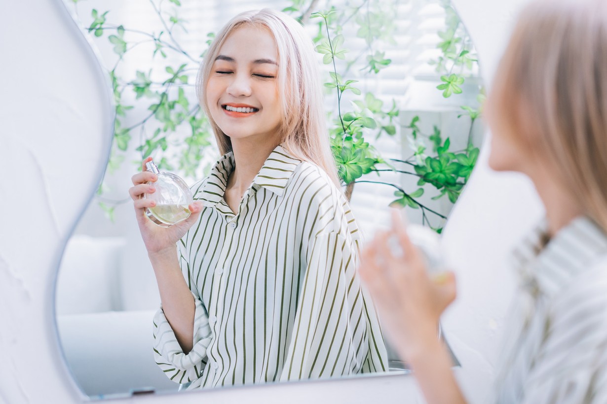 a woman spraying perfume