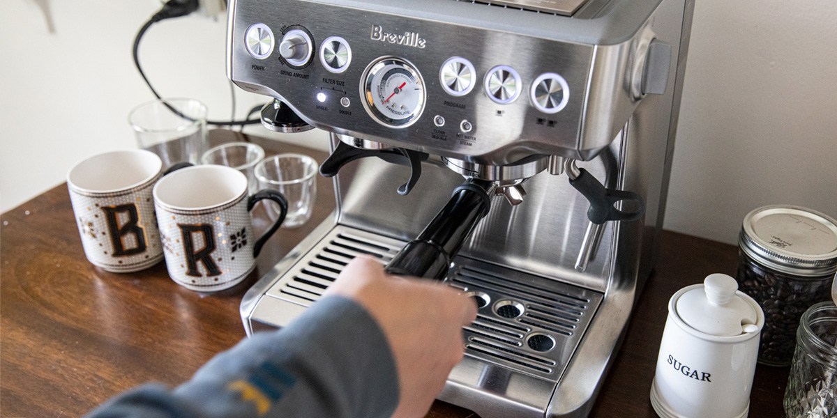 person using Breville Barista Express Espresso Machine
