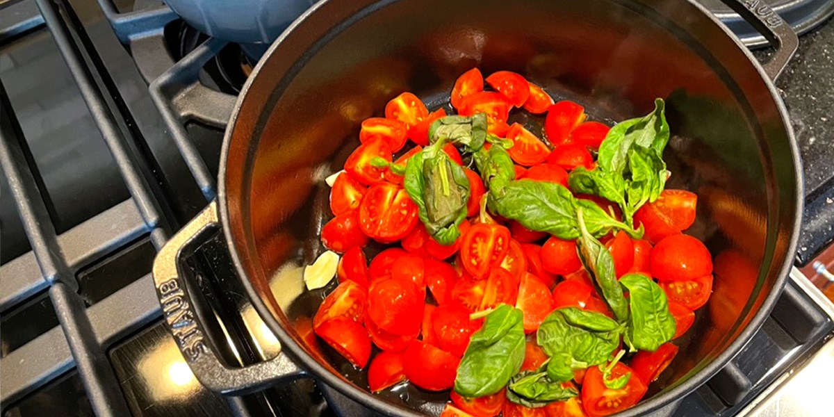 Staub Cast Iron Dutch Oven with tomatoes and spinach inside